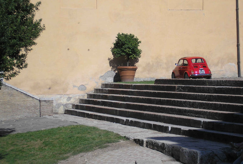 Kleines rotes Auto auf großer langer Treppe