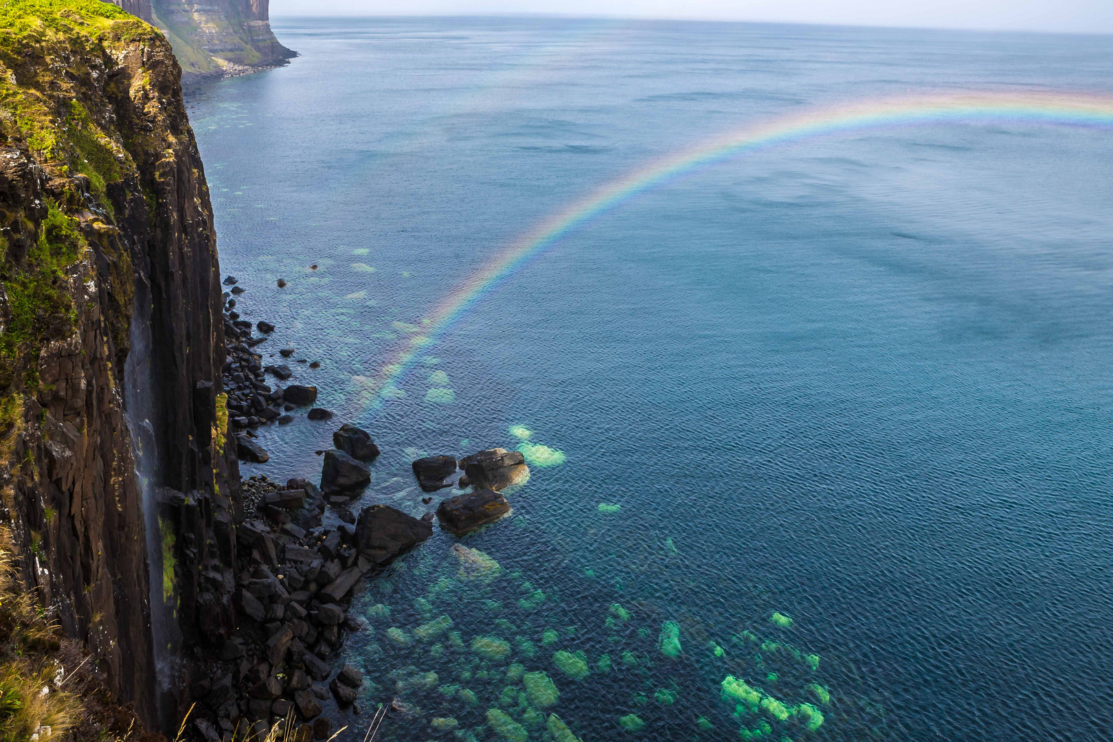 Klippe und liegender Regenbogen