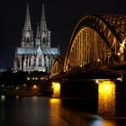 Kölner Dom mit Hohenzollern Brücke bei Nacht.