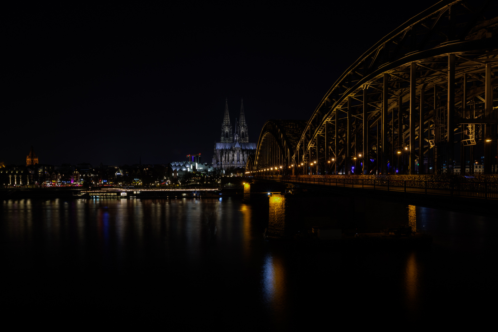 Kölner Kräne, der Dom und die Hohenzollernbrücke im Dunkeln