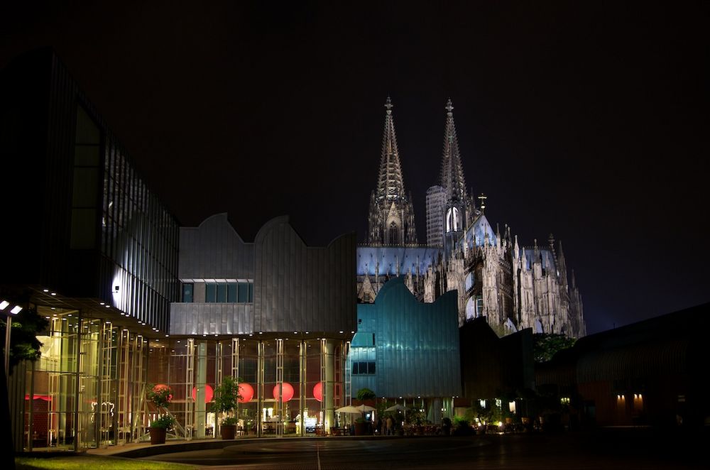 Kölner Philharmonie mit Sicht auf den Dom bei Nacht