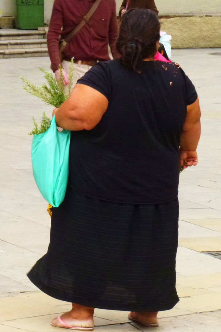 Kräuterverkäuferin auf einer Straße, sonntags im spanischen Valencia