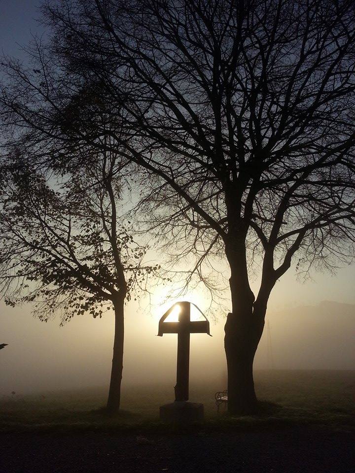 Kreuz am Wegesrand bei Sonnenaufgang