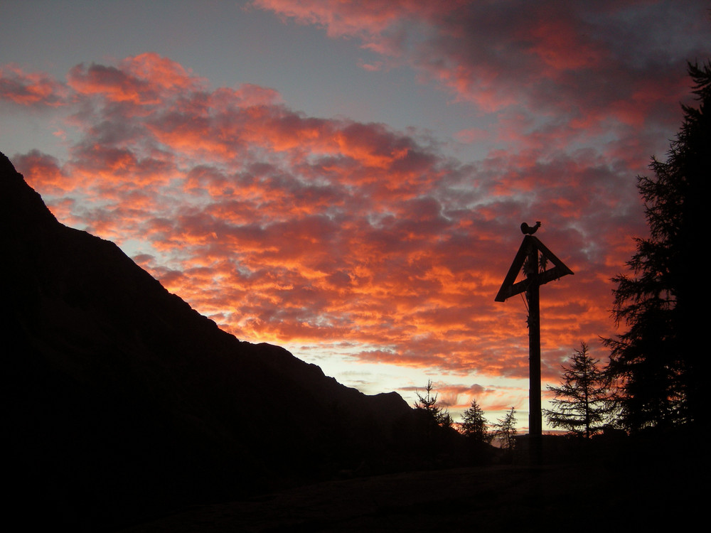 Kreuz vor brennendem Himmel