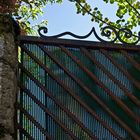 La Tour du Cardinal d’Aux vue à travers la porte d’un jardin à la Romieu