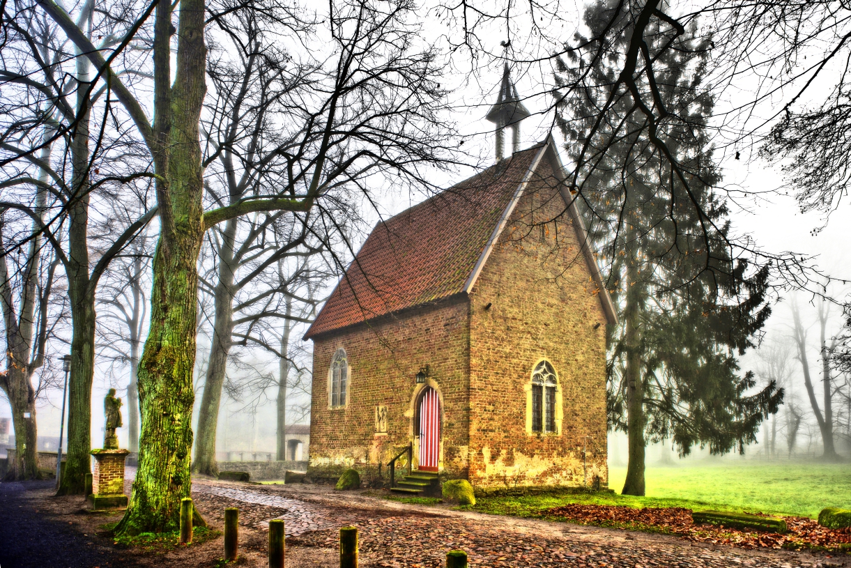 Ländliche Kapelle mit Statue im Morgendunst