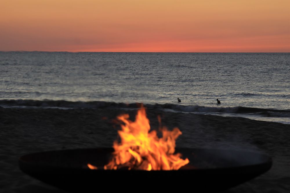 Lagerfeuer am Strand bei Sonnenuntergang
