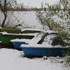 laghetto ghiacciato con barchette innevate