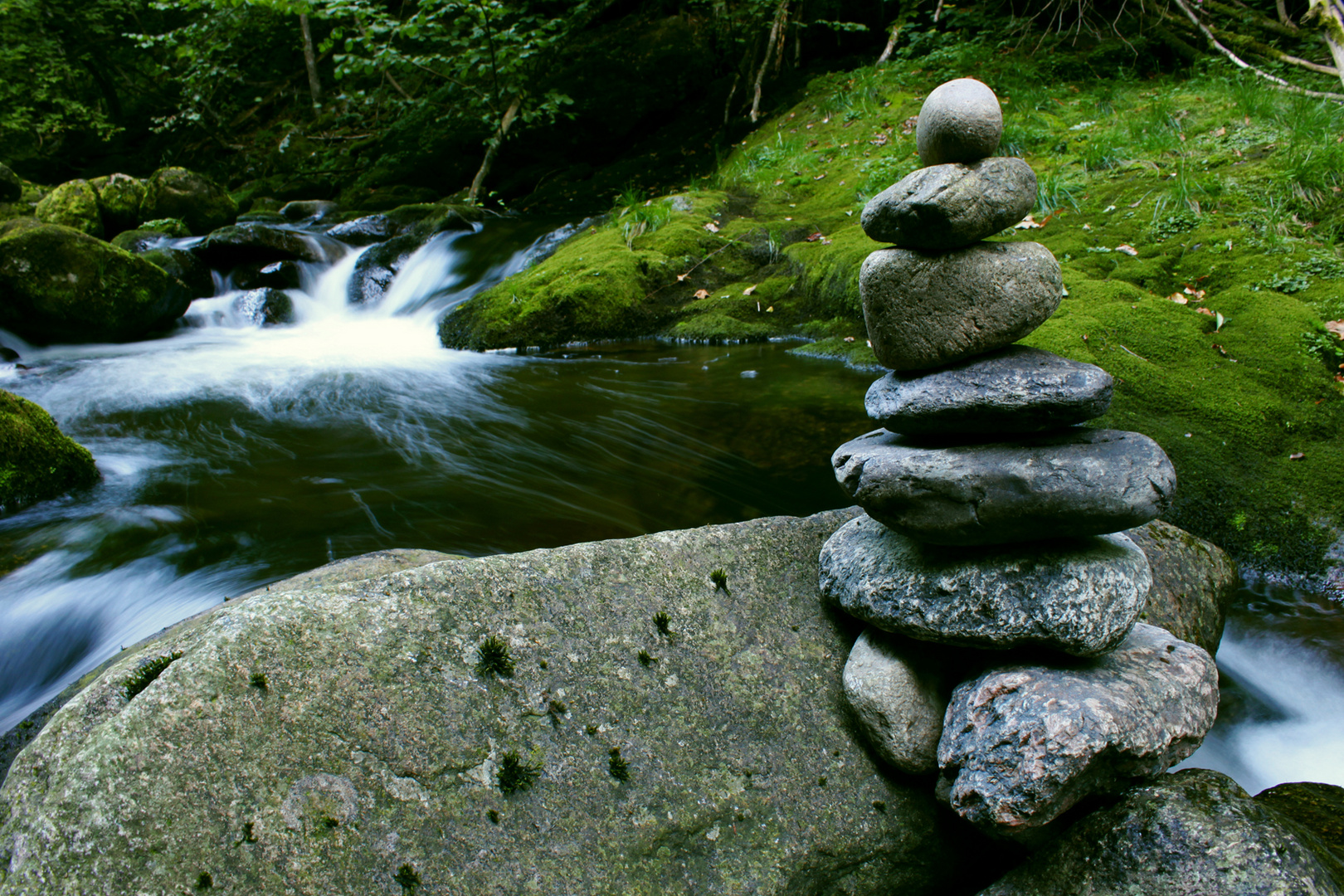 Landart mit Steinen am Bach