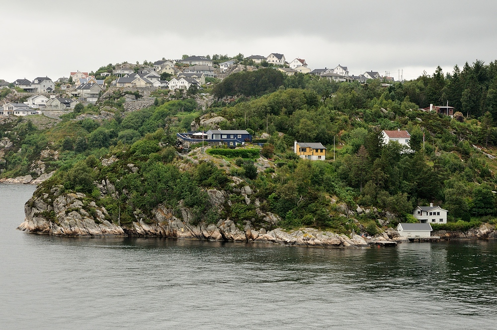 Landestypische Häuser stehen links und rechts in den Fjorden.