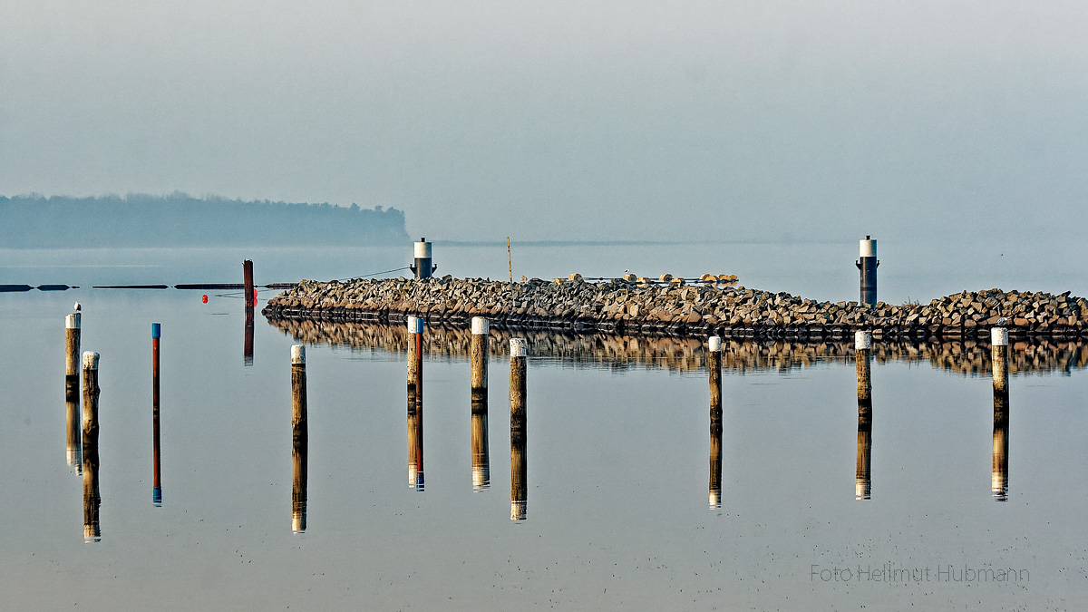 LANDSCHAFT AM MEER ZWISCHEN SPIEGELUNG UND BEGINNENDEM NEBEL