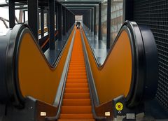 Lange orangene Rolltreppe mit Personen