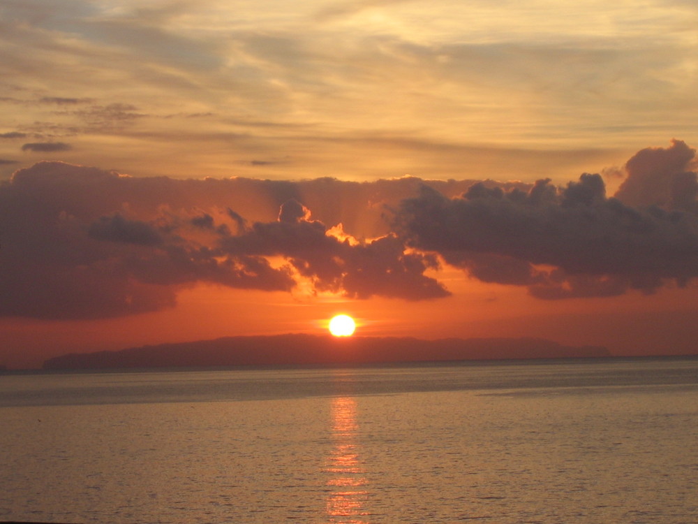 Langsam taucht die Sonne ins Meer