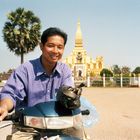 Laotischer Freund mit zum Verzehr bestimmten Würgeschlangen vor dem That Luang