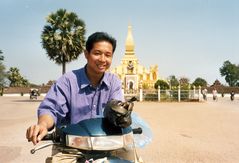 Laotischer Freund mit zum Verzehr bestimmten Würgeschlangen vor dem That Luang