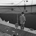 Le petit pêcheur sur le ponton dans le port.