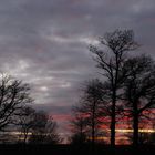 le soleil se couche sur la campagne sarthoise .