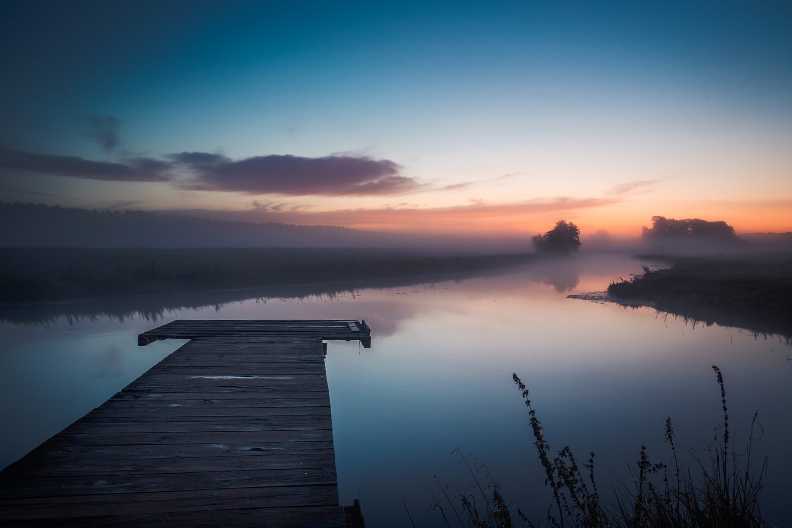 Leerer Steg zur blauen Stunde