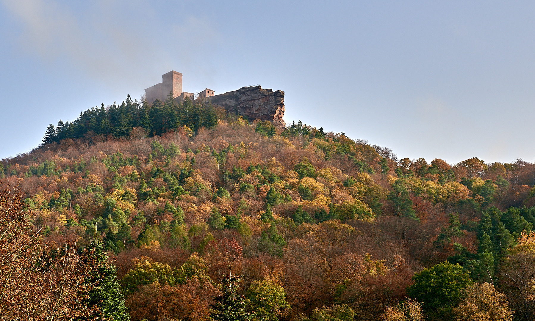 Leichter Hochnebel umgibt die Burg Trifels, sie wirkt wie ein großes Schiff aus der Perspektive.