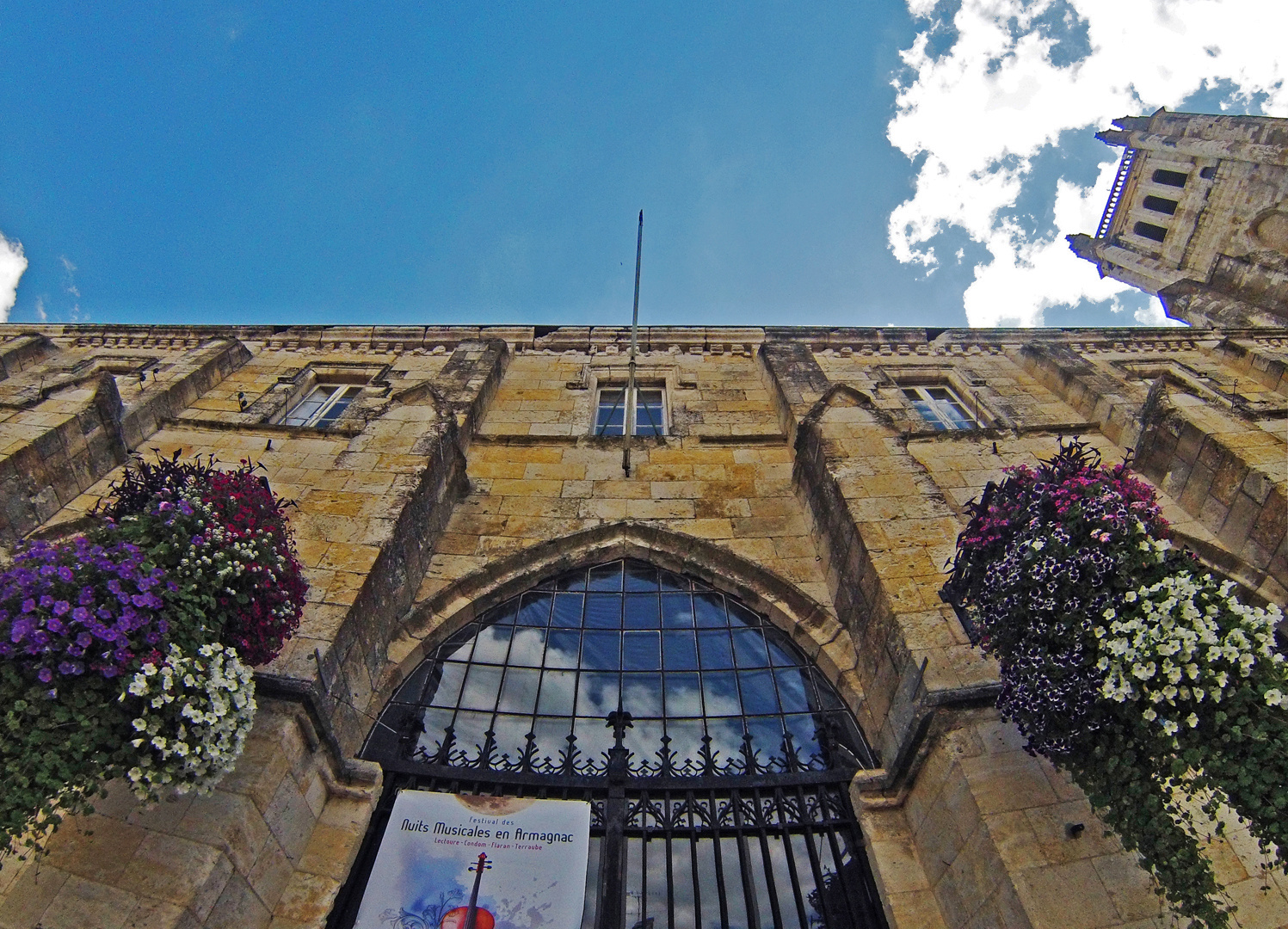 L'entrée de la façade ouest du cloître et le clocher de la Cathédrale Saint-Pierre de Condom