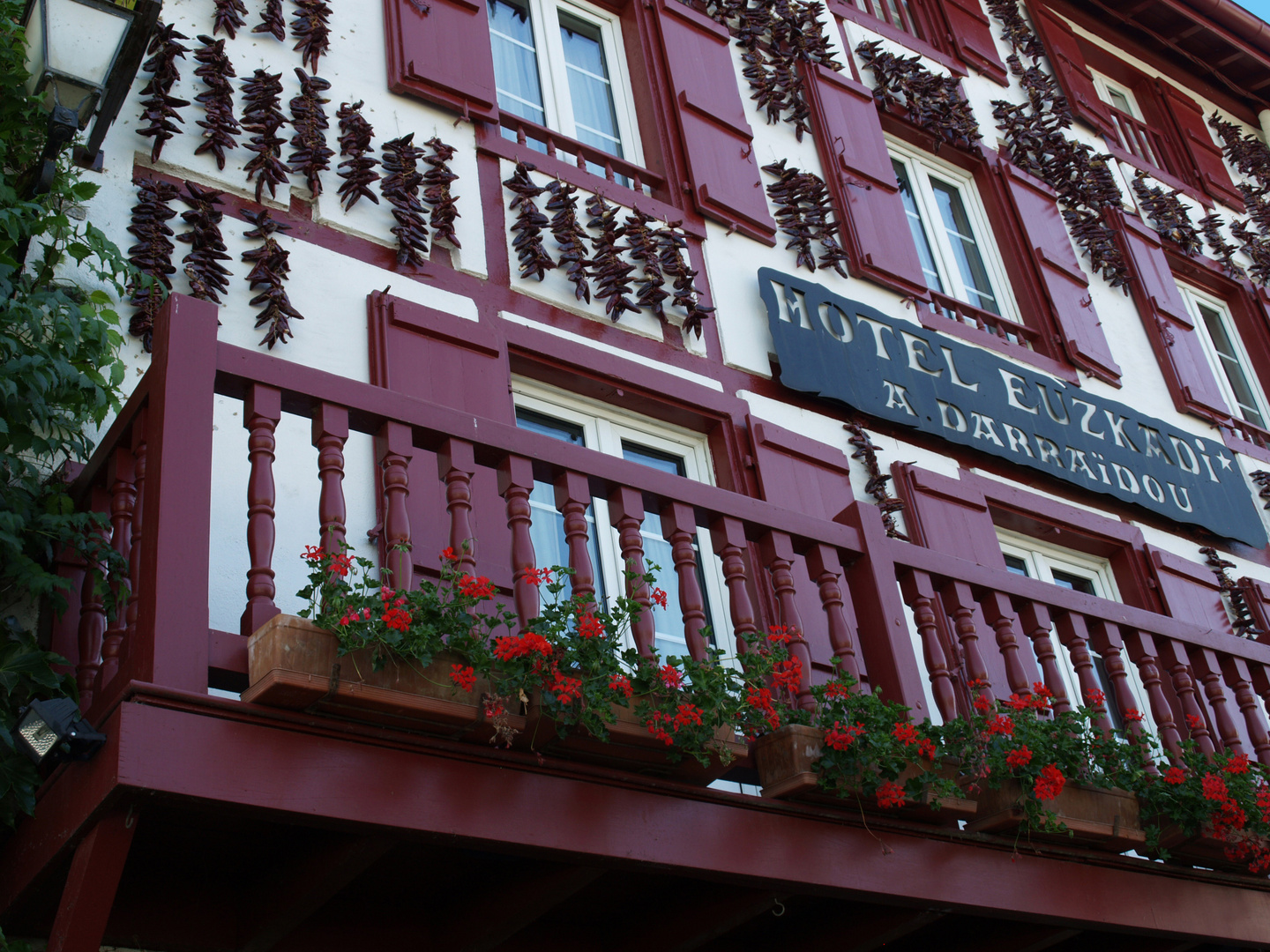 Les balcons de l’Hôtel Euzkadi à Espelette, décorés de géraniums et piments séchés.