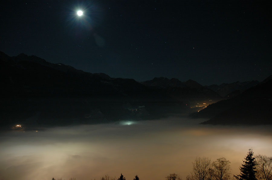 Leuchtender Nebel im Tal mit Mond