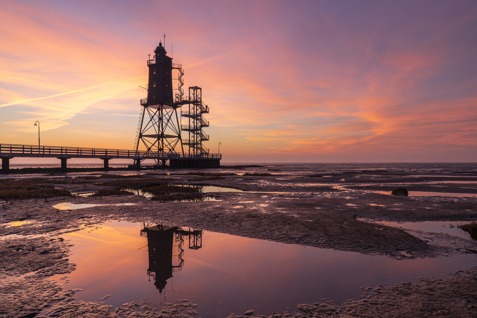 Leuchtturm Obereversand bei Ebbe und Sonnenuntergang