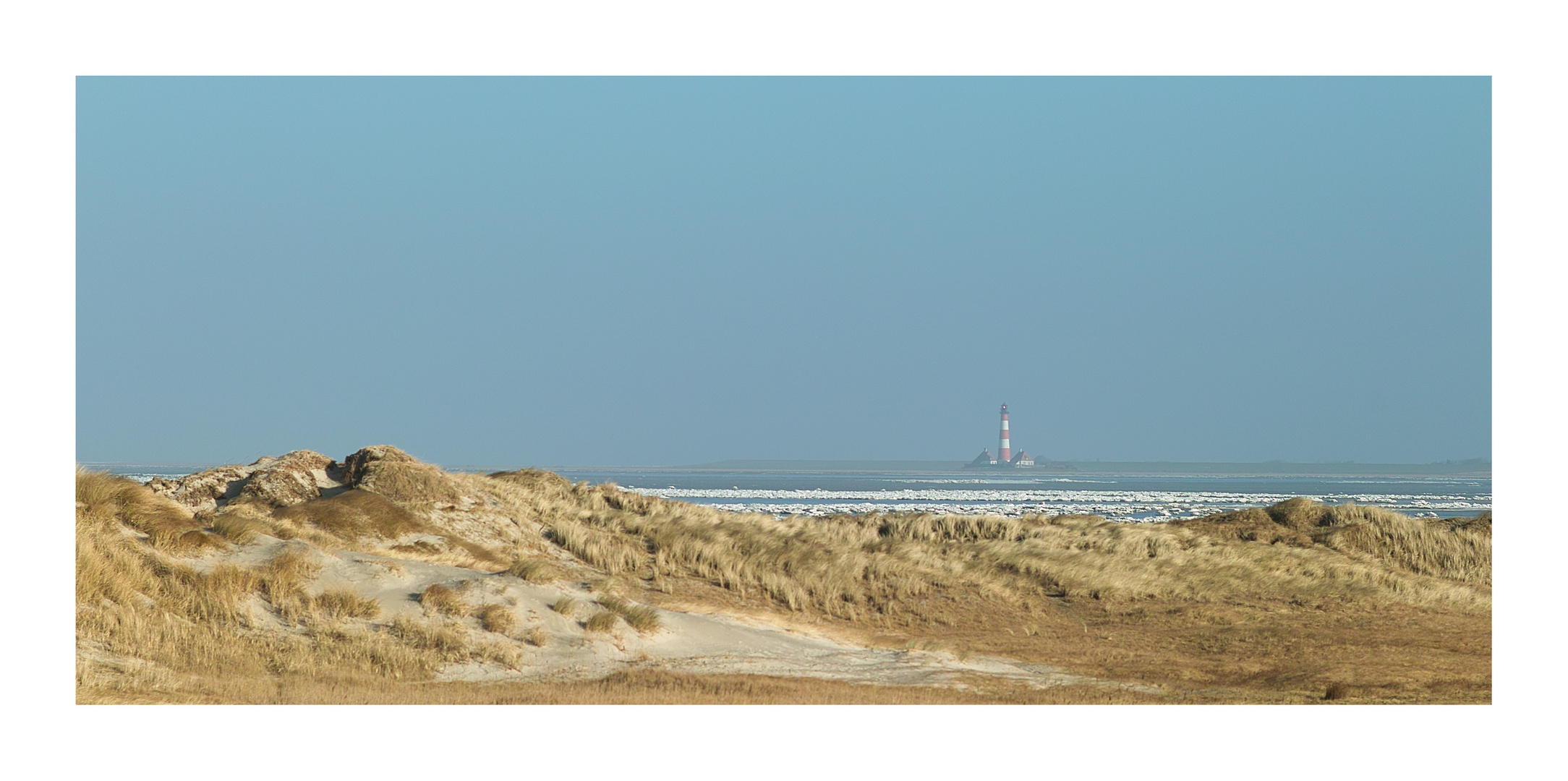 Leuchtturm Westerhever in eisiger Landschaft.