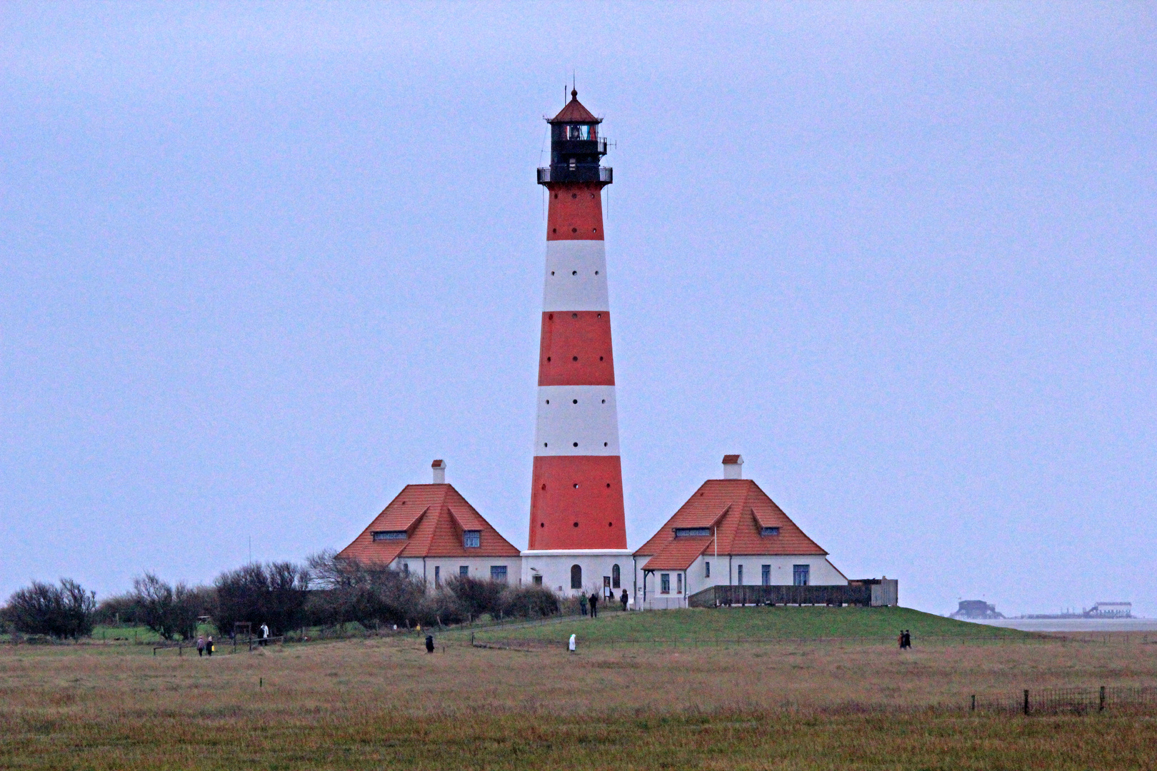 Leuchtturm Westerheversand mit in der Ferne liegenden Pfahlbauten von St. Peter-Ording