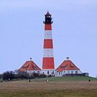 Leuchtturm Westerheversand mit in der Ferne liegenden Pfahlbauten von St. Peter-Ording