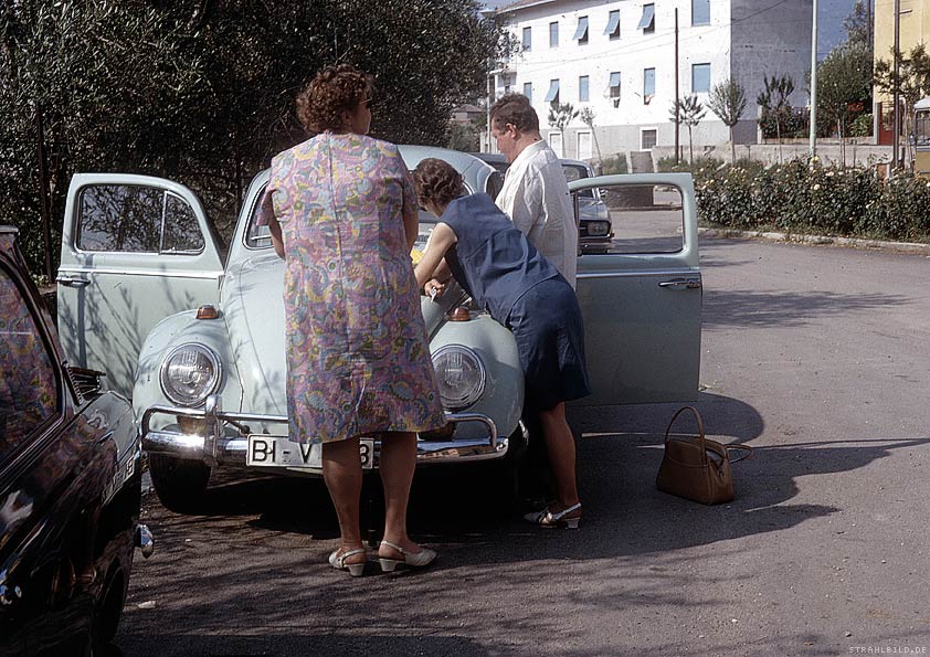 leute vor auto vor haus geparkt