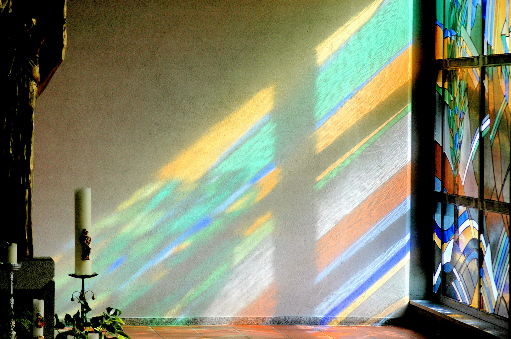 Lichteinfall durch ein Buntglasfenser in einer Kirche in Aystetten