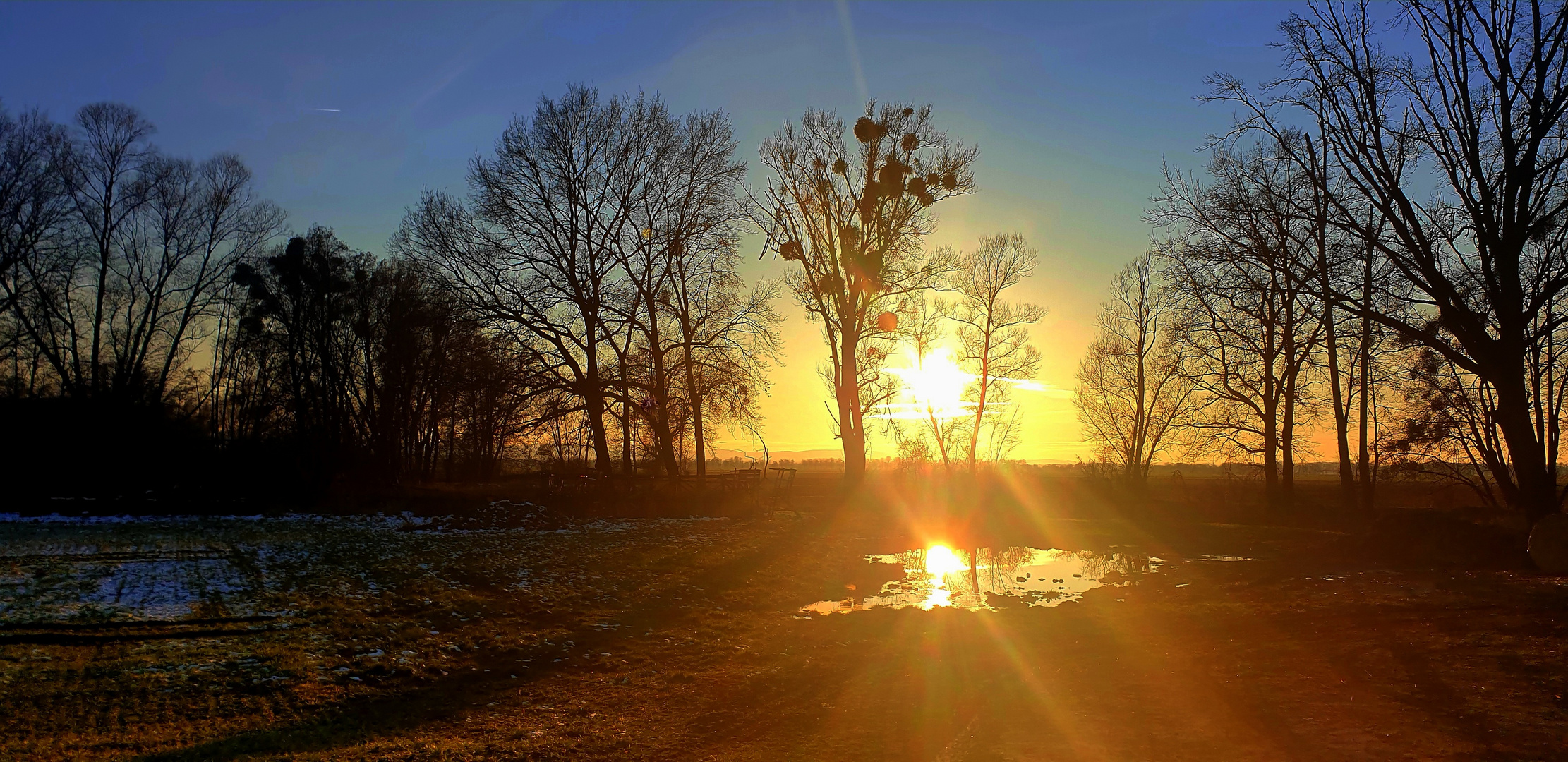 Lichtreflexe und Spiegelung der untergehenden Sonne