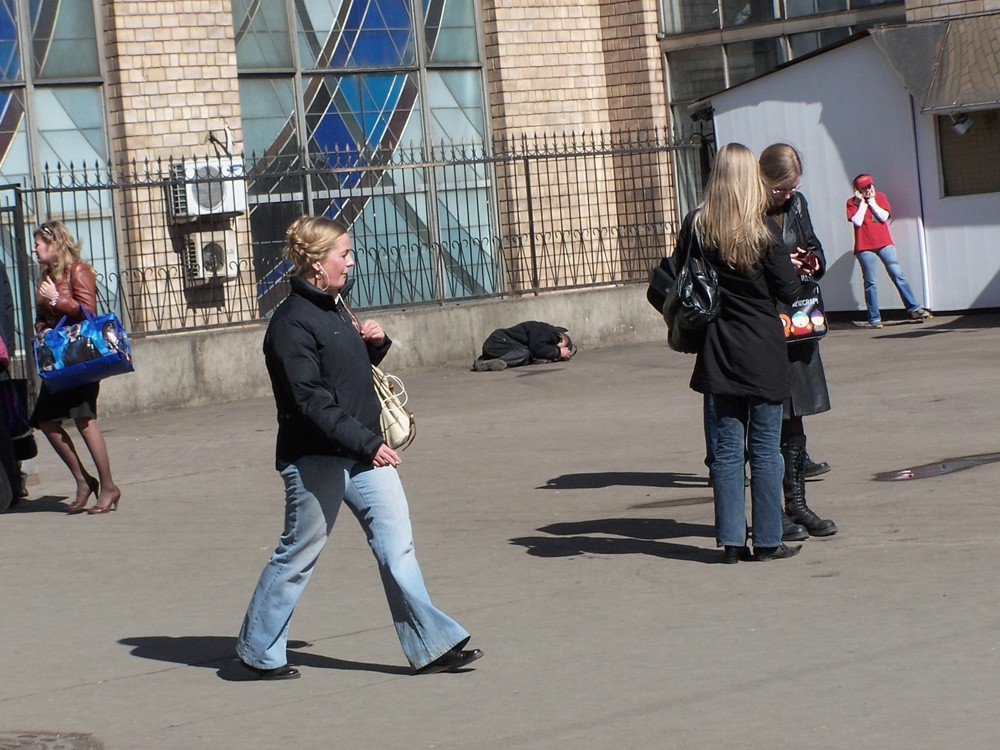 Liegender auf nacktem Beton unter hartem Eisen und unter Menschen in schiefem Bild