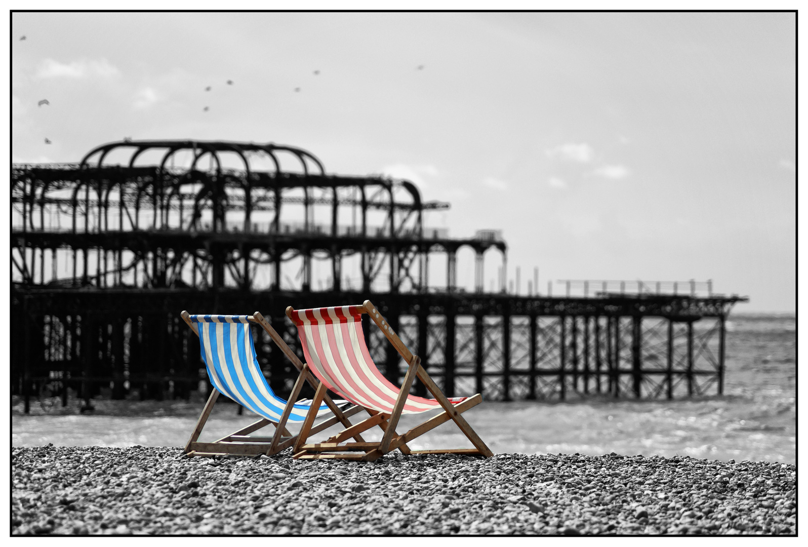 Liegestühle vor abgebranntem Brighton-Pier