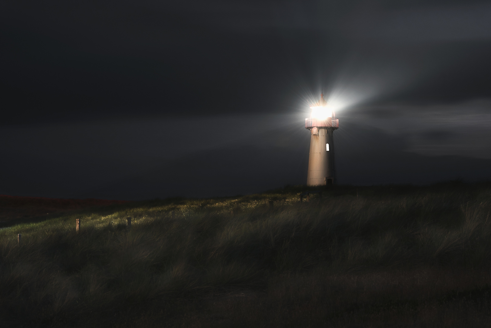 Lighthouse at night on Sylt island, at North sea,  on dunes