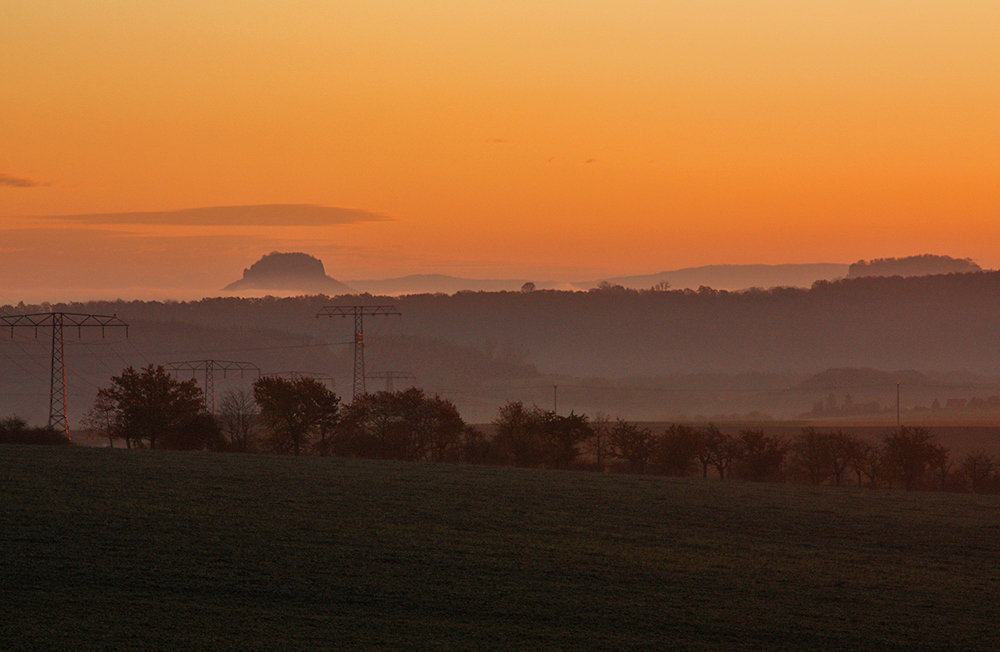 Lilienstein und Festung Königstein ragen aus dem Elbnebel und werden...