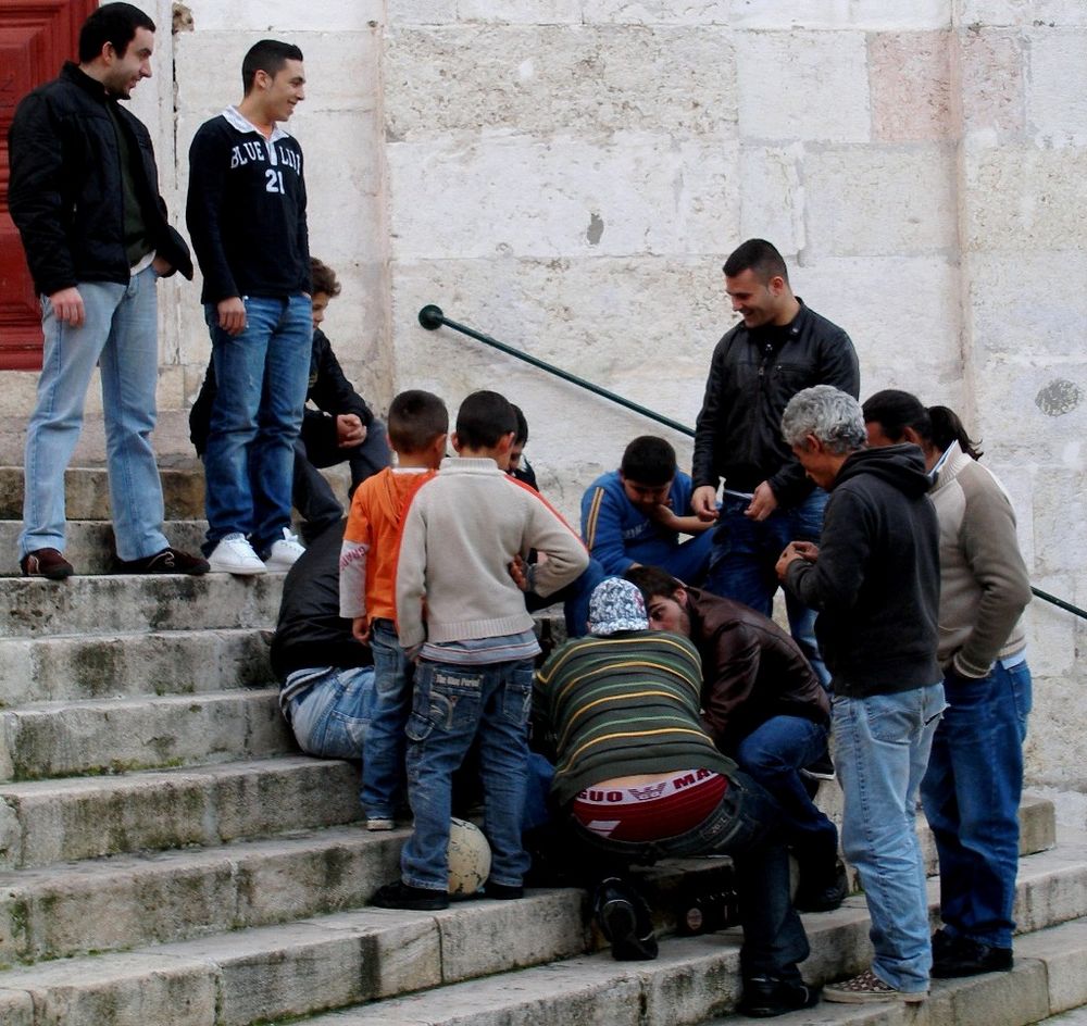 Lissabon: alle sind eng dabei beim Kartenspielen auf der Kirchentreppe