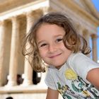 Little girl posing in front of a roman temple