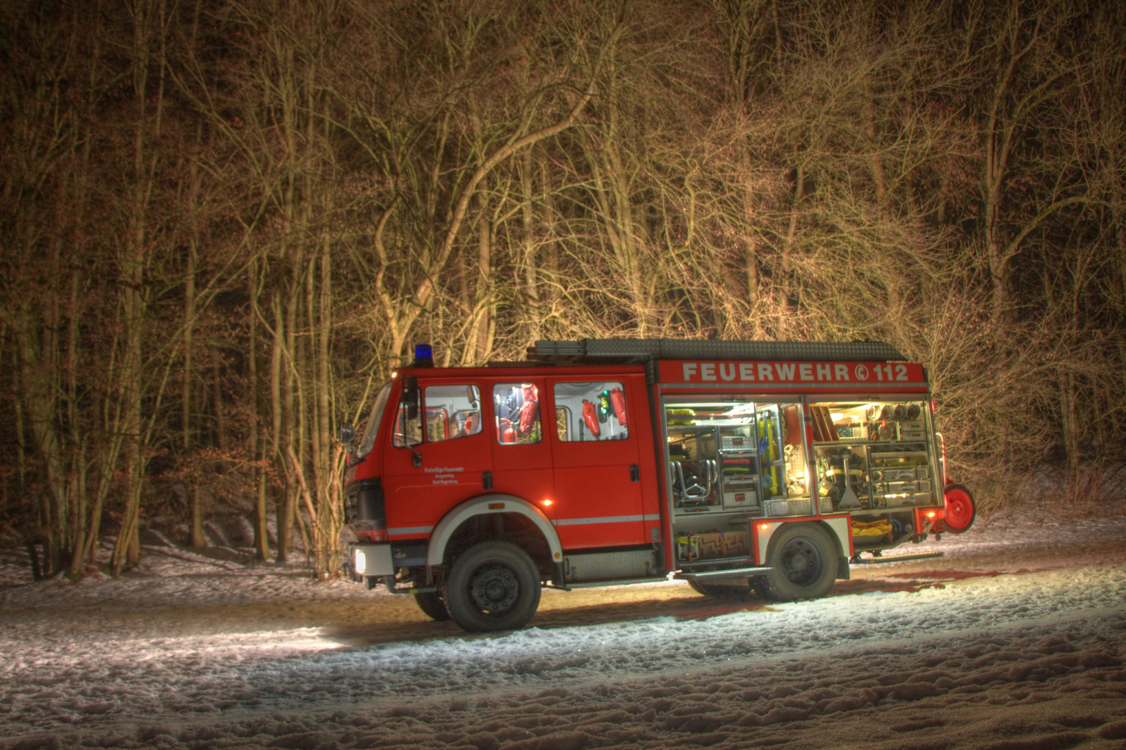 Löschfahrzeug vor winterlichem Wald