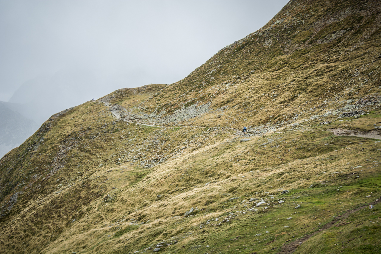 Lone hikers at rolling mountains of Penser Joch