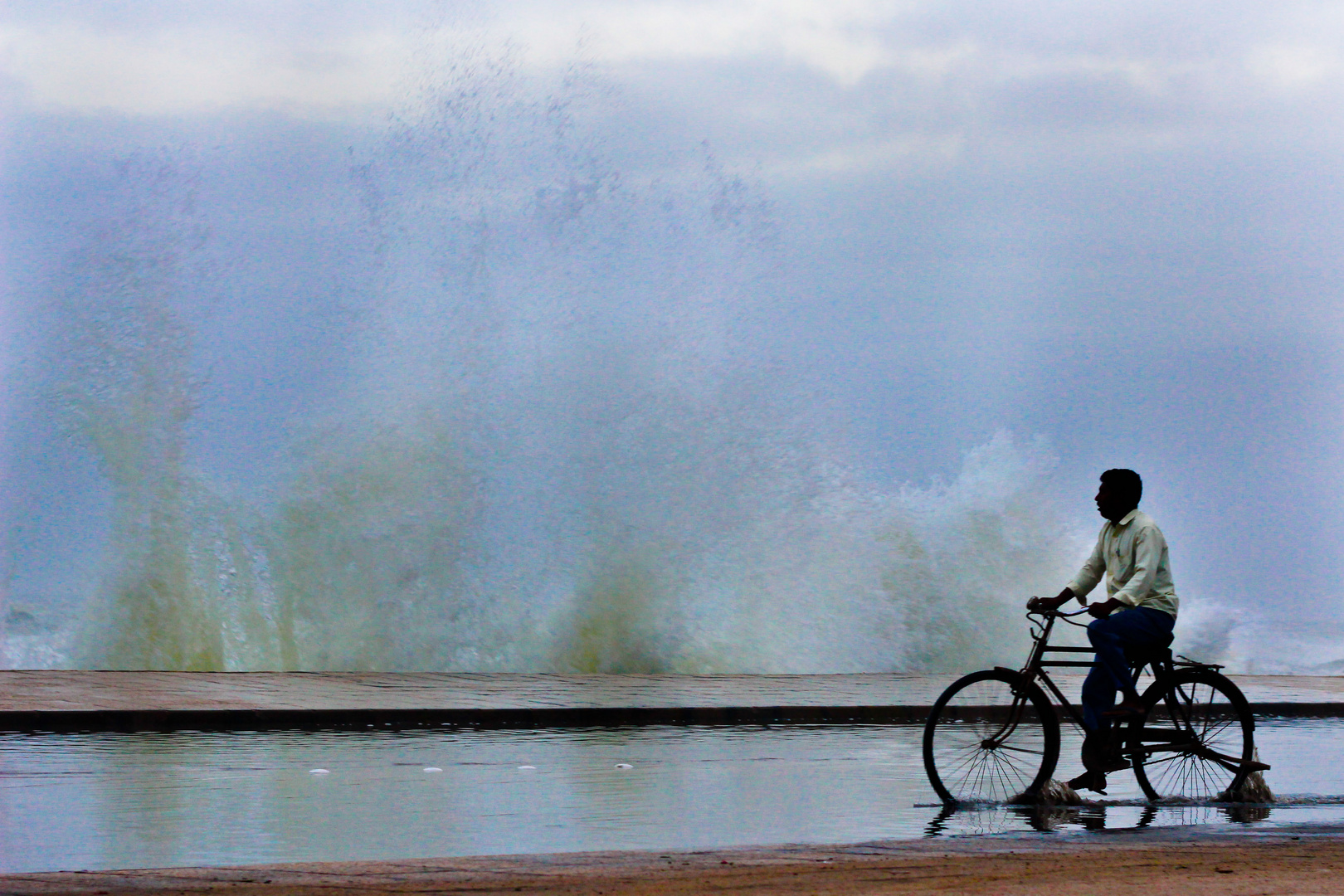 lonely cyclist at high tide