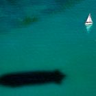 Lonely sailingboat and the zeppelin shadow