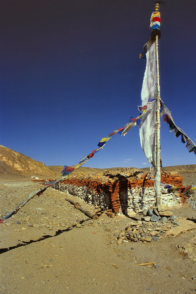 Long mani wall and a prayer flag in Tholing