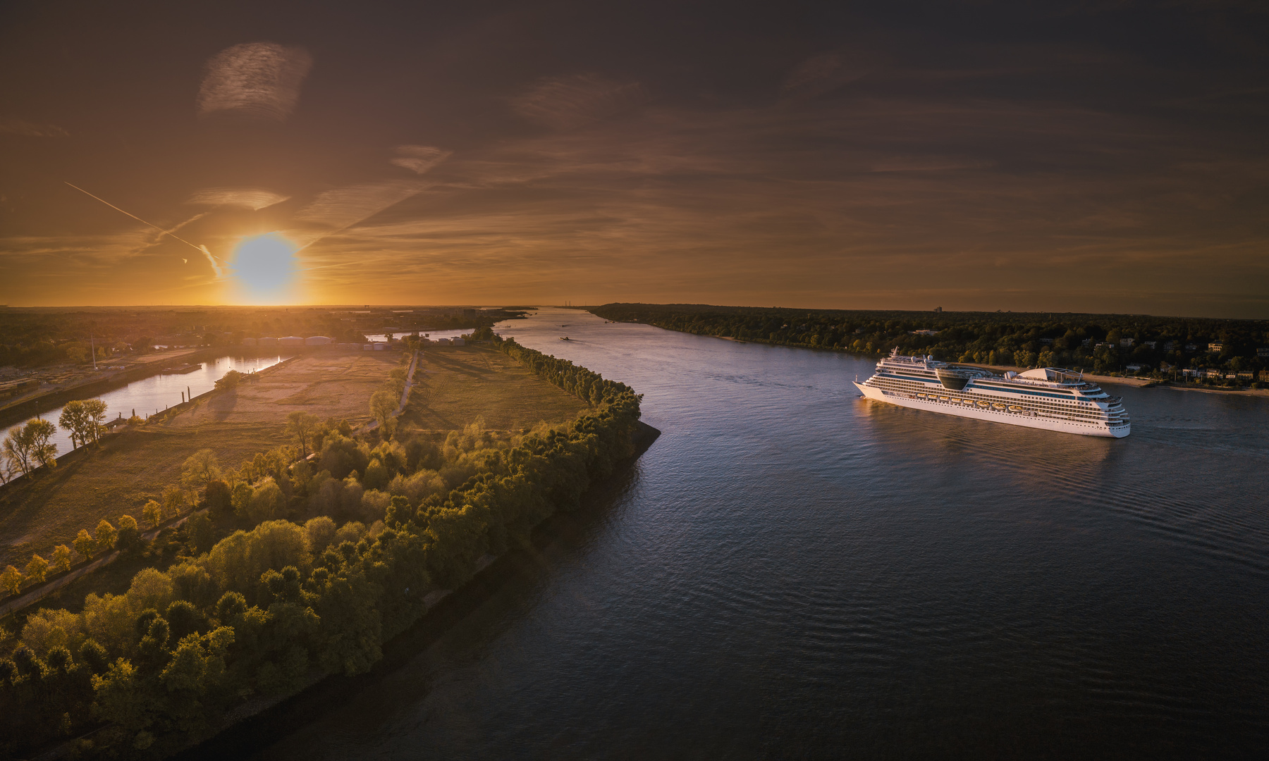     Luftaufnahme eines Kreuzfahrtschiffes auf der Elbe in Fahrt bei Sonnenuntergang 