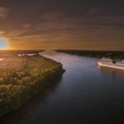     Luftaufnahme eines Kreuzfahrtschiffes auf der Elbe in Fahrt bei Sonnenuntergang 