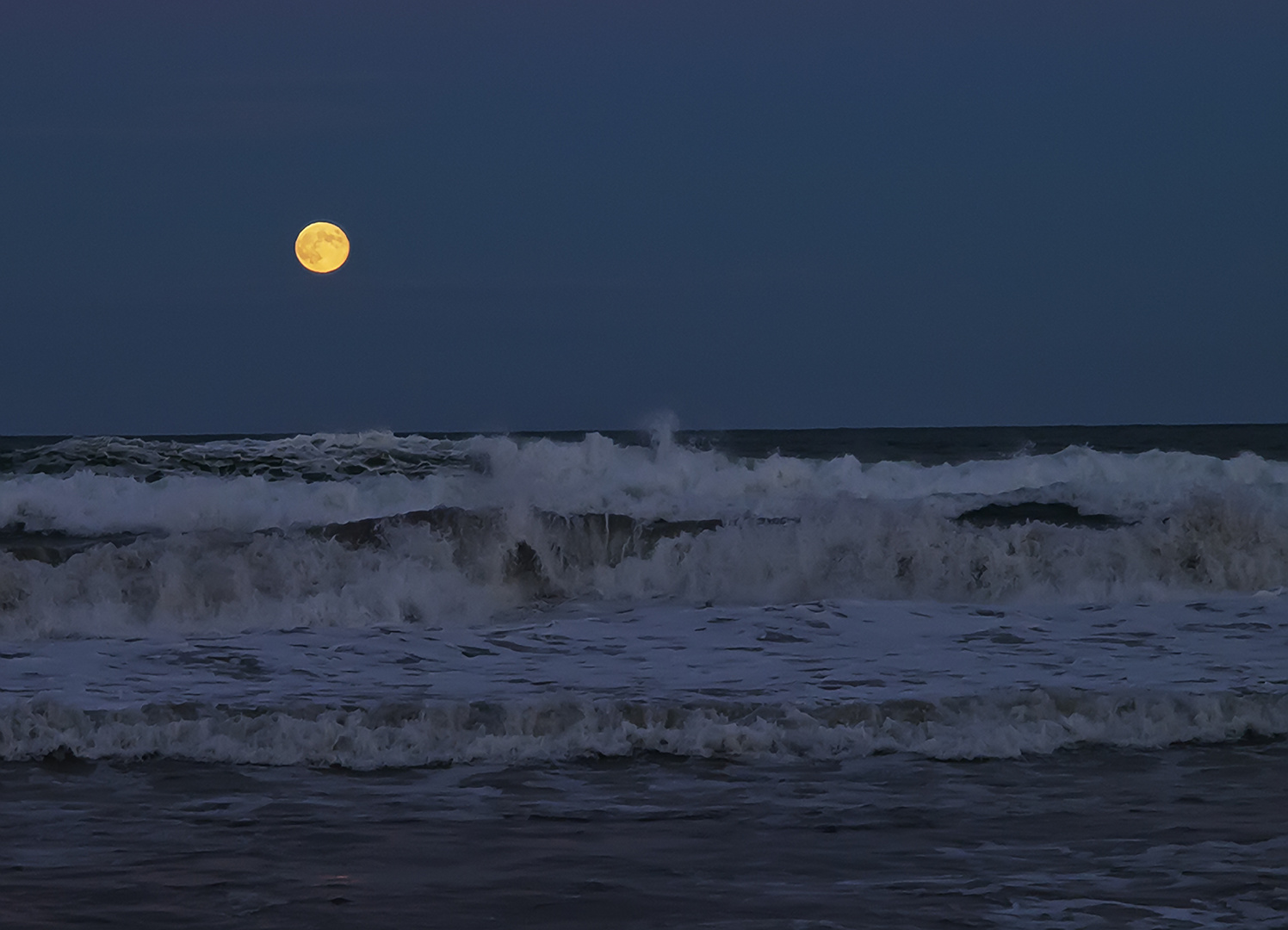 Luna llena sobre las olas.