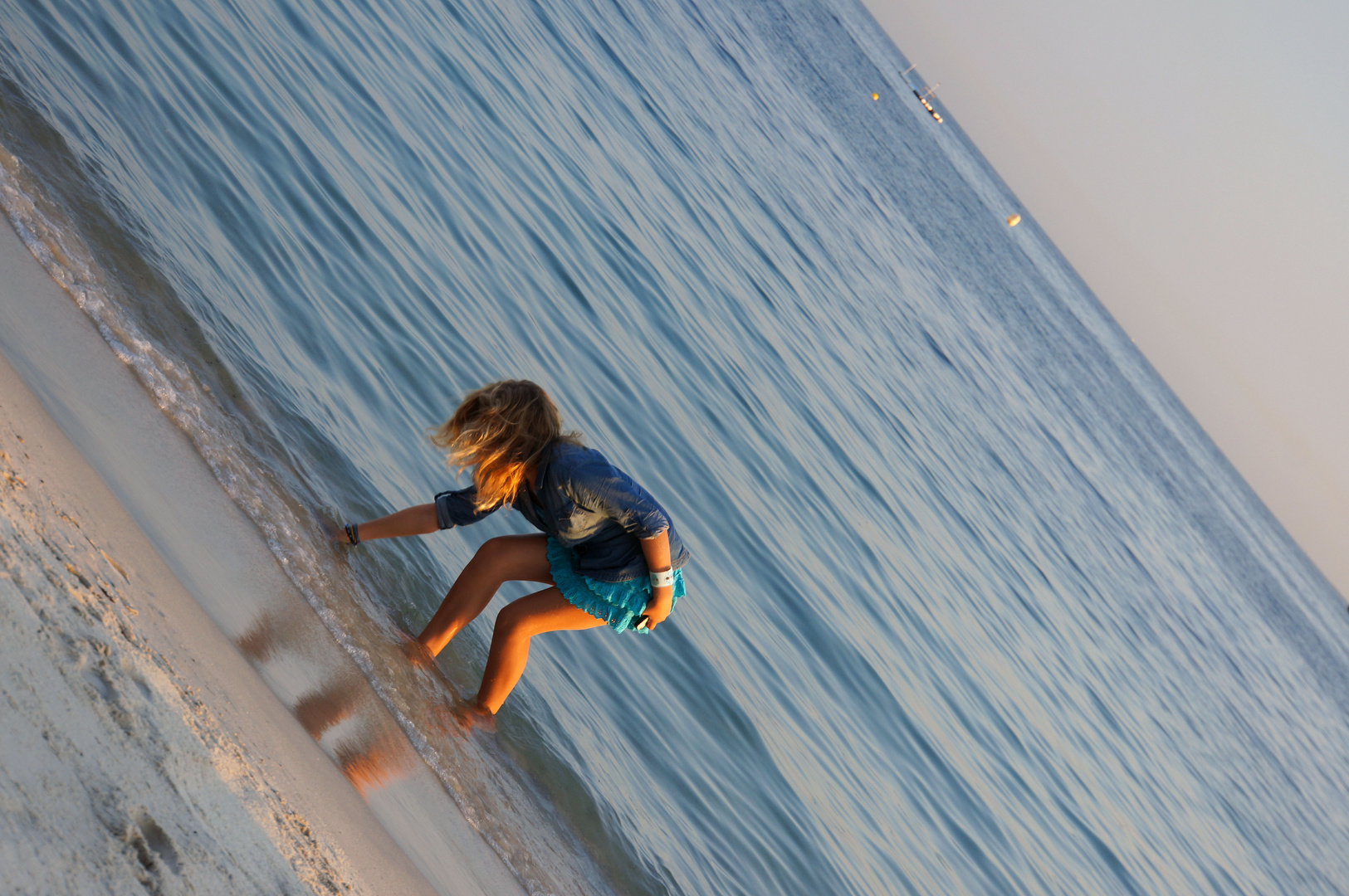 Mädchen beim Muschelsuchen am Strand von Juan-les-Pins