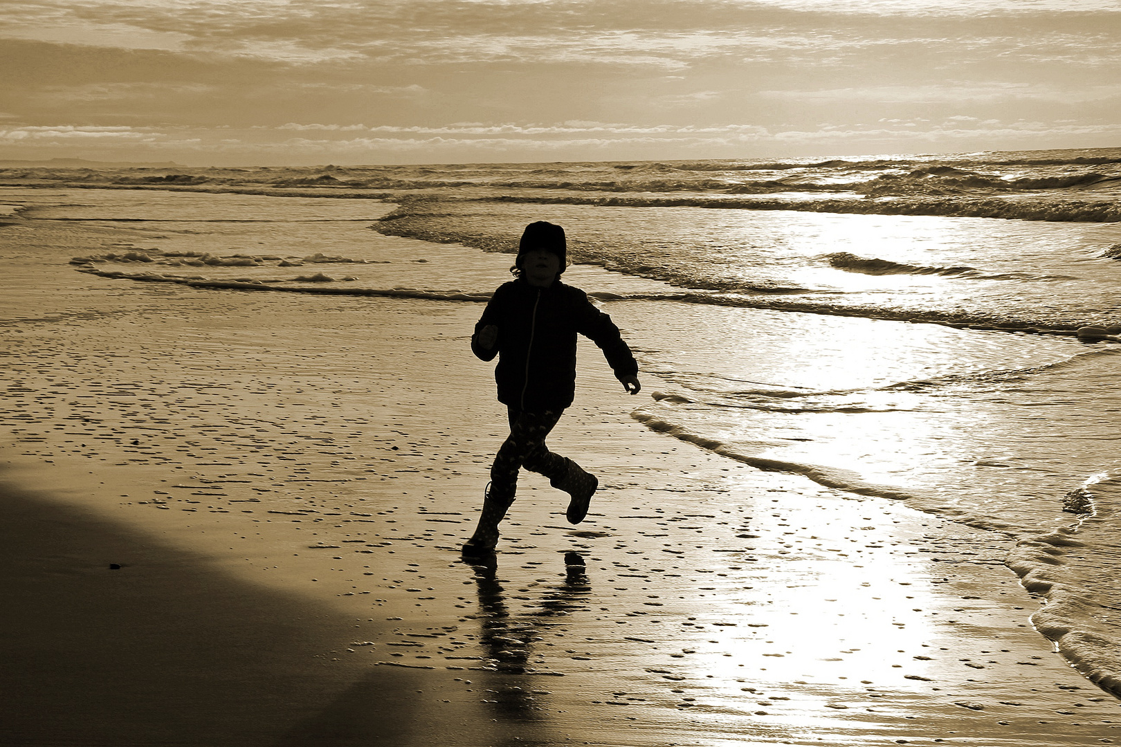 Mädchen rennt im Abendlicht am Strand