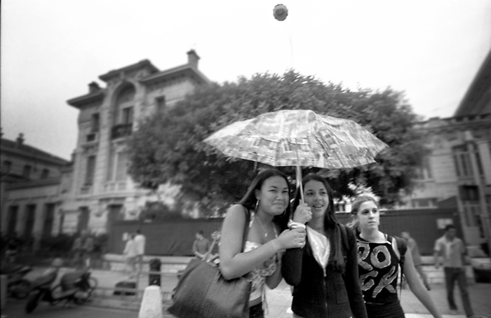 Mädchen unter Schirm und Ballon. Nizza, September 2004